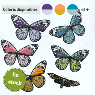 6 papillons en tissus brodés ressortent sur un fond gris clair. 5 d'entre eux ont la même forme et sont dans des coloris vives et variées (tons violets, tons bleus, tons verts, tons roses et tons orangés, au choix). Le 6ème est plus petit, et représente un papillon sphinx tête de mort. Ces papillons sont montés sur des barrettes à cheveux. En haut de l'image se trouvent des vignettes indiquant les coloris disponibles, et en bas à gauche se trouve un macaron indiquant "en stock".