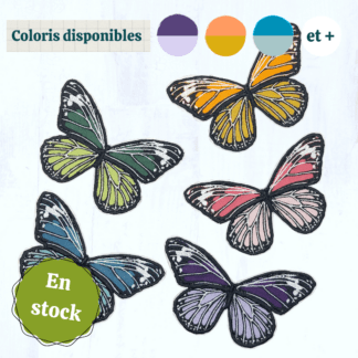 5 papillons en tissus brodés ressortent sur un fond gris clair. Ils ont la même forme et sont dans des coloris vives et variées (tons violets, tons bleus, tons verts, tons roses et tons orangés, au choix). Ces papillons sont des patch à thermocoller. En haut de l'image se trouvent des vignettes indiquant les coloris disponibles, et en bas à gauche se trouve un macaron indiquant "en stock".